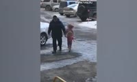 Мужчина идет по улице с двумя раздетыми детьми