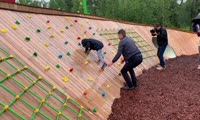 Сергей Ерёмин помогает мальчику спуститься по «скалодрому» на Татышеве