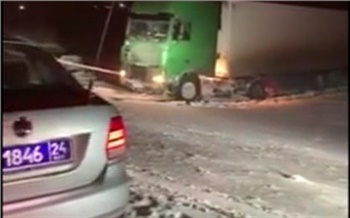 Под Красноярском фура съехала с трассы и увязла в снегу. Вытаскивали двумя грузовиками
