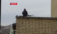 Мужчина с винтовкой на крыше дома