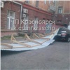 В центре Красноярска строительный забор упал на иномарку